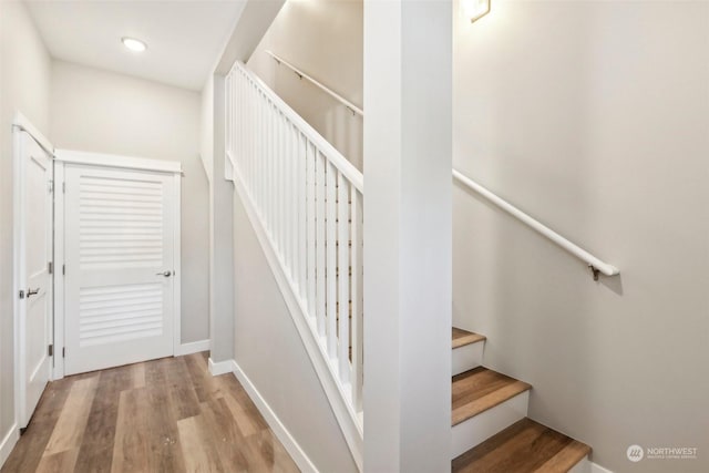 staircase with hardwood / wood-style floors