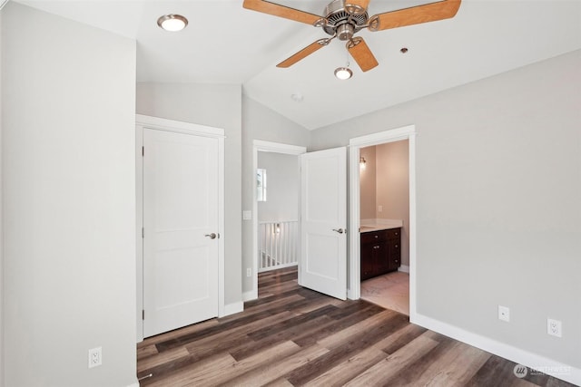 unfurnished bedroom with lofted ceiling, dark hardwood / wood-style flooring, and ensuite bath