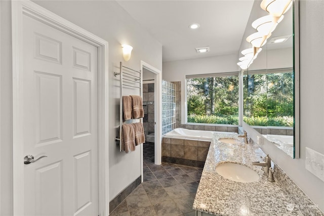 bathroom featuring vanity and tiled tub