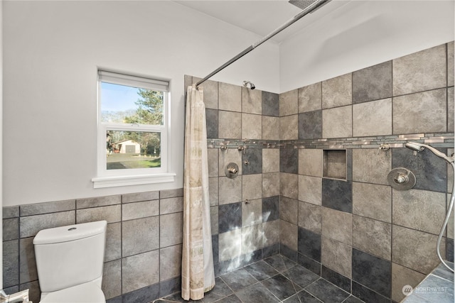 bathroom with walk in shower, toilet, and tile walls