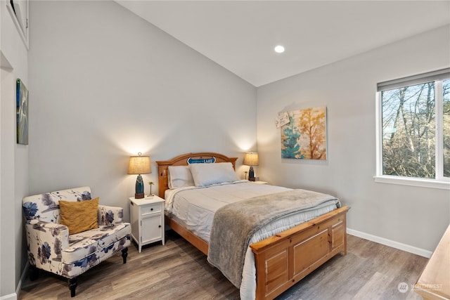 bedroom featuring hardwood / wood-style floors and vaulted ceiling