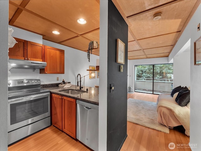 211 Summit Ave E Unit N308, Seattle, WA 98102 - kitchen featuring stainless steel appliances, under cabinet range hood, open floor plan, brown cabinetry, and recessed lighting