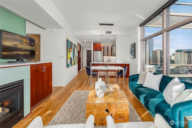 living room featuring a wall of windows and light hardwood / wood-style flooring