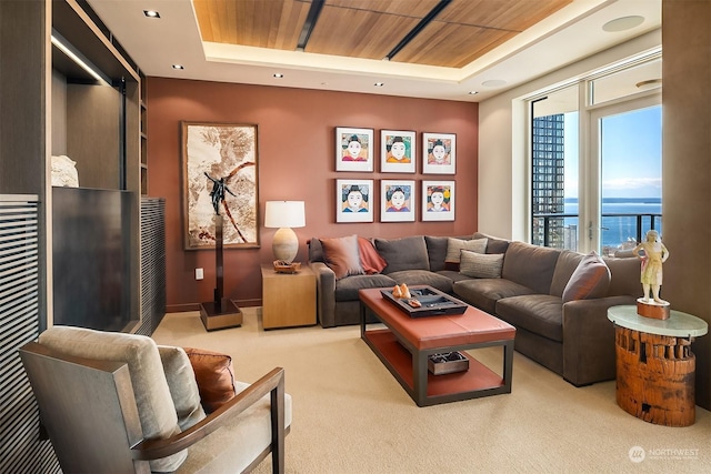 living room featuring a water view, light carpet, wooden ceiling, and a tray ceiling