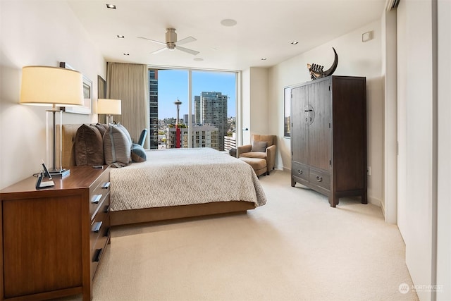 bedroom featuring a wall of windows, access to exterior, and light carpet