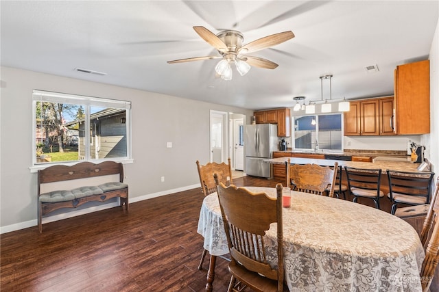 dining room featuring dark wood-type flooring, ceiling fan, and sink