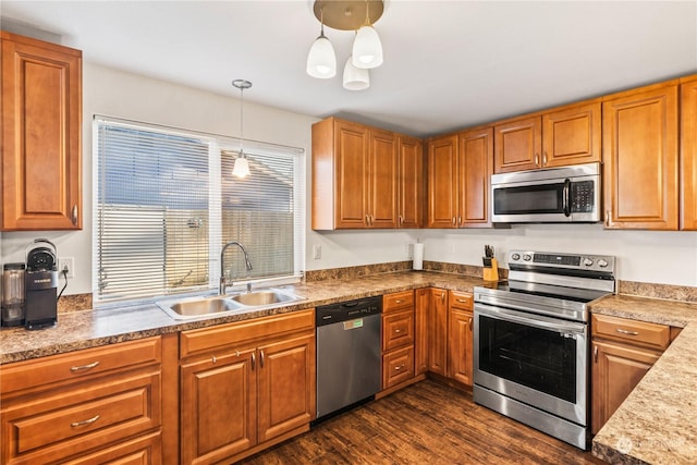 kitchen featuring sink, decorative light fixtures, dark hardwood / wood-style floors, and appliances with stainless steel finishes