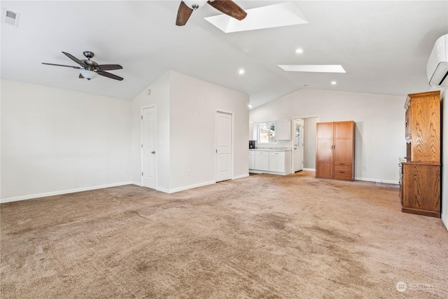 unfurnished living room with ceiling fan, light colored carpet, and lofted ceiling with skylight