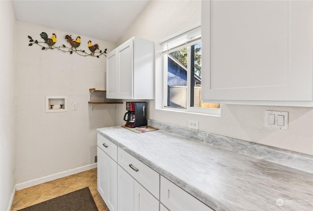 washroom featuring cabinets, hookup for a washing machine, and light tile patterned floors