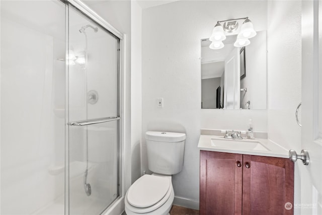 bathroom with a shower with door, vanity, and toilet