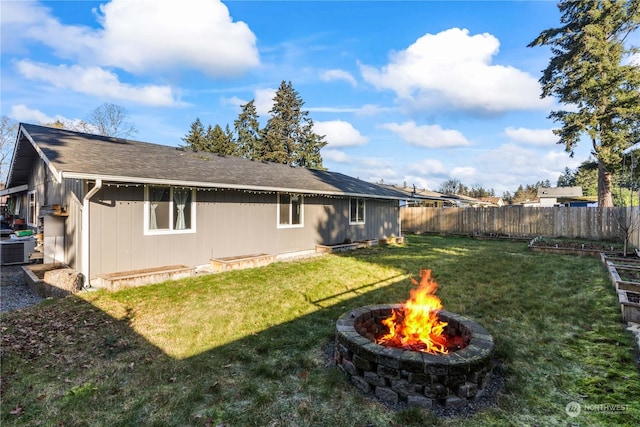 rear view of house featuring an outdoor fire pit and a lawn