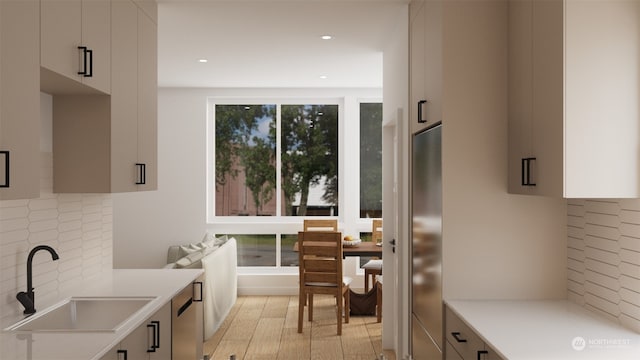 kitchen with stainless steel appliances, white cabinetry, sink, and decorative backsplash