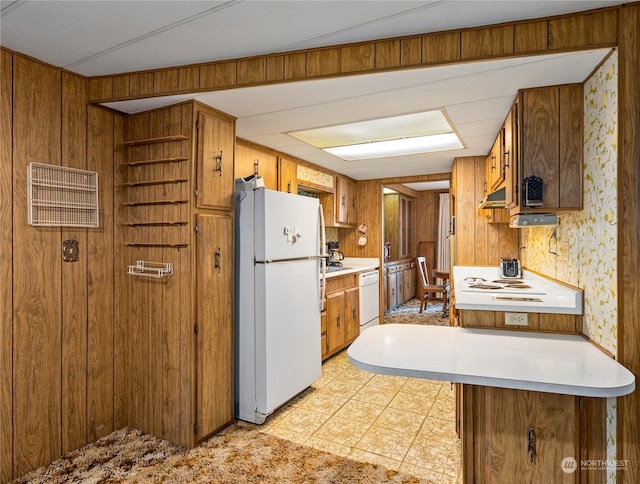 kitchen featuring white appliances and wood walls