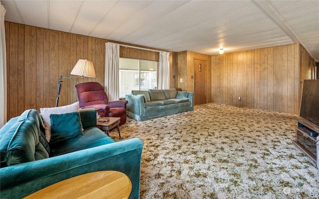 carpeted living room featuring wooden walls