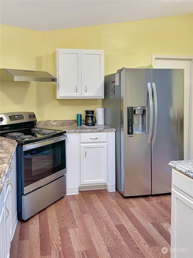 kitchen featuring white cabinetry, light hardwood / wood-style flooring, light stone countertops, and appliances with stainless steel finishes