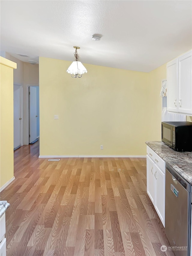 kitchen with decorative light fixtures, white cabinetry, stainless steel dishwasher, light stone counters, and light wood-type flooring