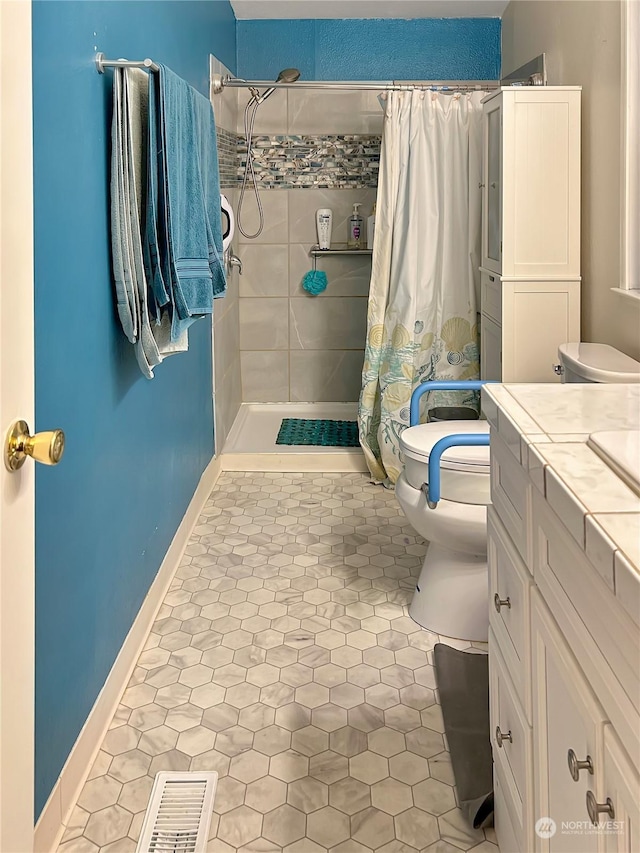 bathroom featuring toilet, vanity, tile patterned floors, and walk in shower