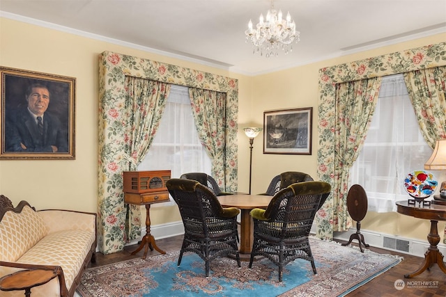 sitting room featuring crown molding, wood-type flooring, and a notable chandelier