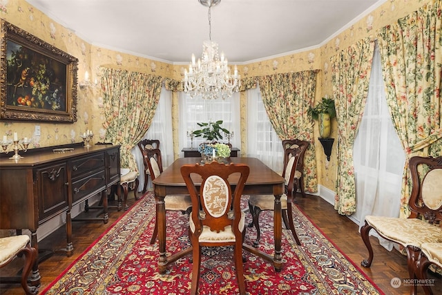 dining area featuring dark parquet flooring, ornamental molding, and an inviting chandelier