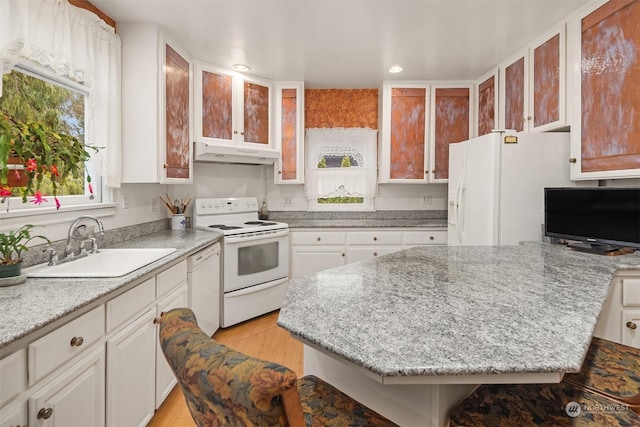 kitchen with sink, white appliances, white cabinetry, light stone counters, and light hardwood / wood-style floors