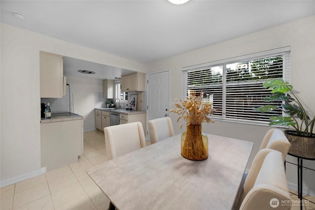 dining space with a healthy amount of sunlight, light tile patterned floors, and baseboards