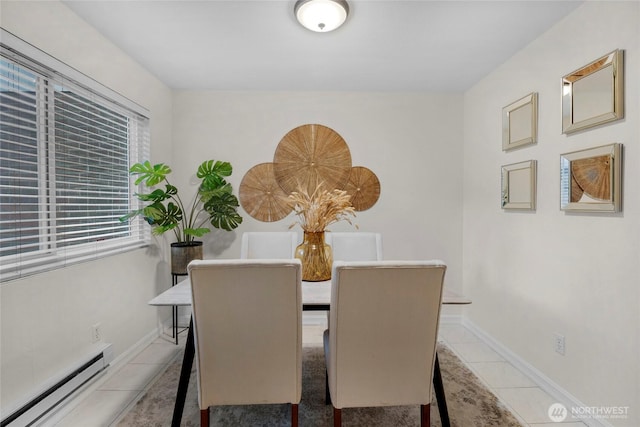 dining space featuring light tile patterned floors, baseboards, and a baseboard heating unit