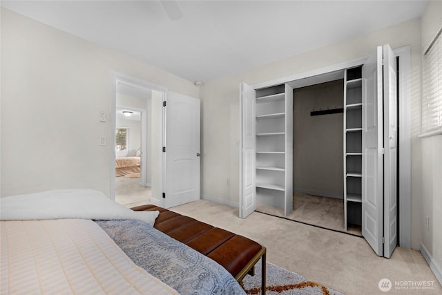 bedroom with light carpet, ceiling fan, and baseboards