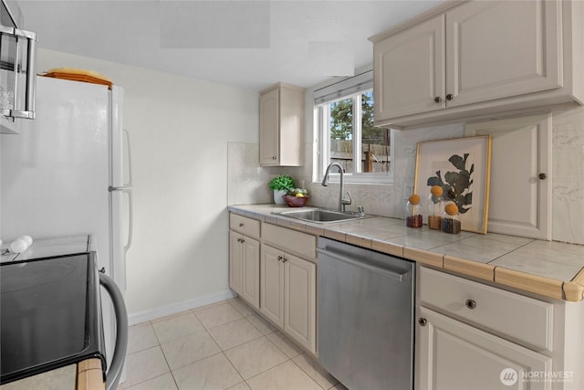 kitchen with electric stove, tile counters, backsplash, a sink, and dishwasher