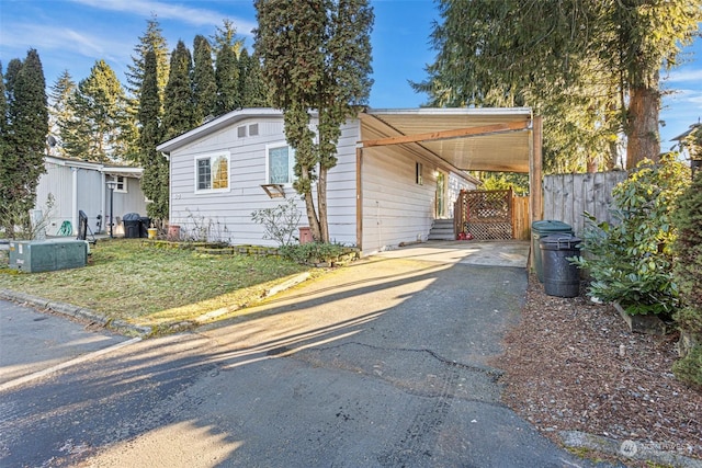 view of side of home with a carport and a yard