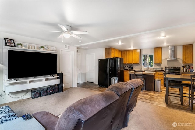 living room featuring sink, light colored carpet, and ceiling fan