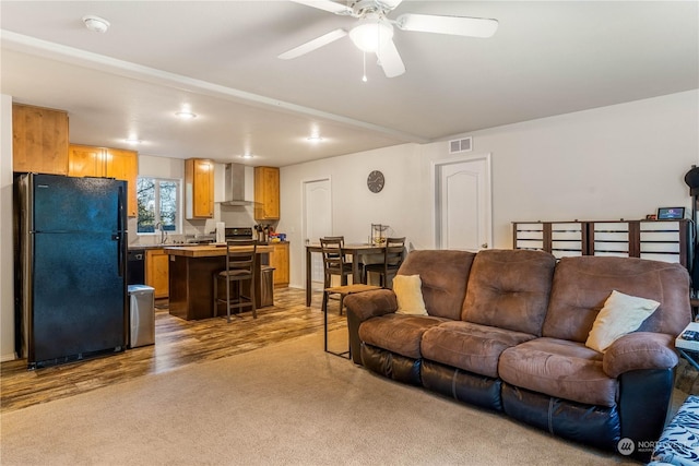 living room featuring light hardwood / wood-style flooring and ceiling fan