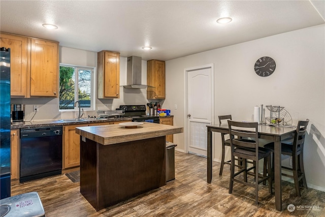 kitchen featuring sink, dark wood-type flooring, a center island, black appliances, and wall chimney exhaust hood