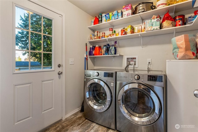 clothes washing area with a wealth of natural light, separate washer and dryer, and hardwood / wood-style floors