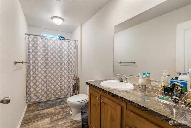 bathroom featuring vanity, wood-type flooring, and toilet