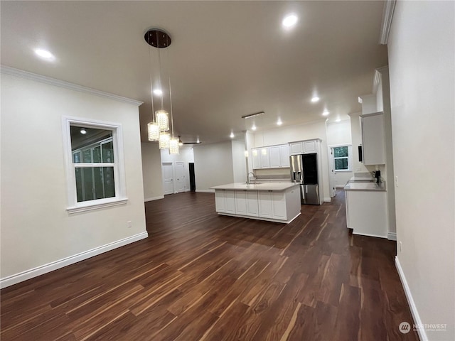 kitchen with pendant lighting, stainless steel fridge with ice dispenser, dark hardwood / wood-style floors, and a center island with sink