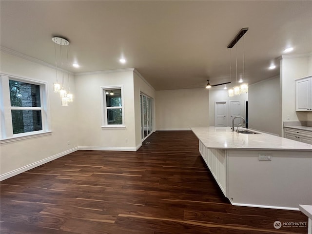 kitchen with white cabinetry, sink, an island with sink, and hanging light fixtures