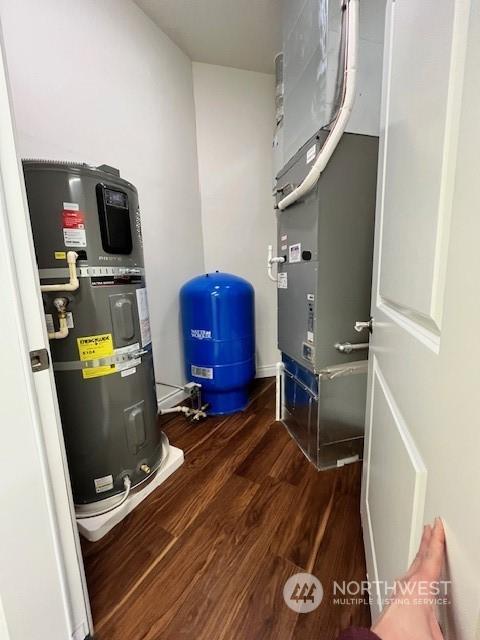 utility room with heating unit and water heater