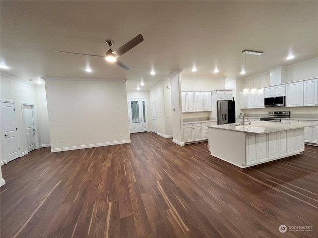 kitchen with white cabinetry, dark hardwood / wood-style flooring, an island with sink, and appliances with stainless steel finishes