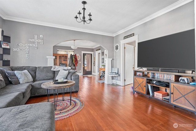 living room with crown molding, wood-type flooring, and a chandelier