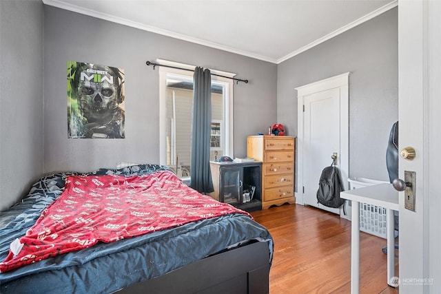 bedroom with hardwood / wood-style flooring and crown molding