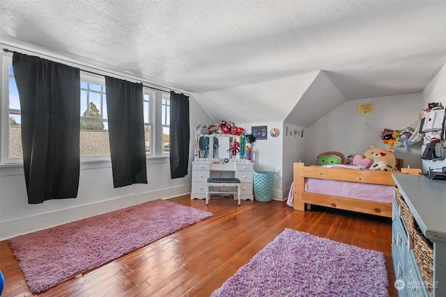 bedroom with dark wood-type flooring, lofted ceiling, and a textured ceiling