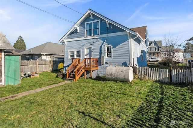 back of house featuring a lawn and a deck