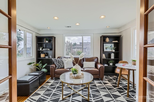 sitting room with ornamental molding, hardwood / wood-style floors, and a wealth of natural light