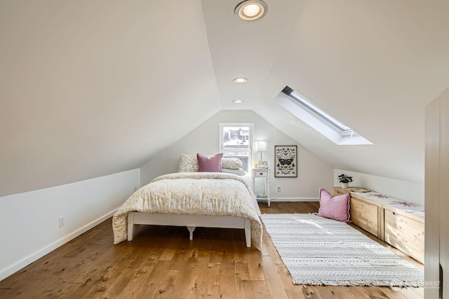 bedroom featuring wood-type flooring and vaulted ceiling with skylight