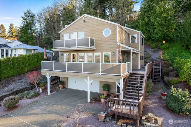 rear view of property featuring a garage and a balcony