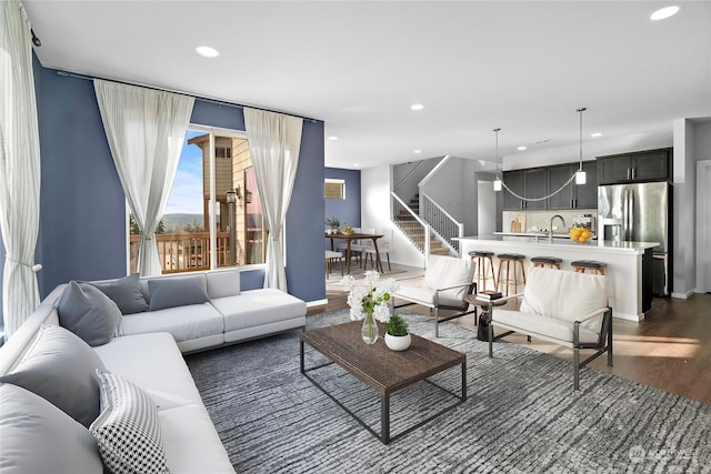 living room with dark hardwood / wood-style flooring and sink