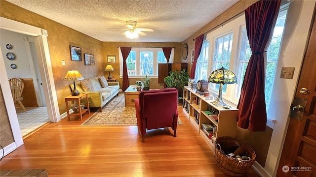 sitting room with ceiling fan, a textured ceiling, and light hardwood / wood-style flooring