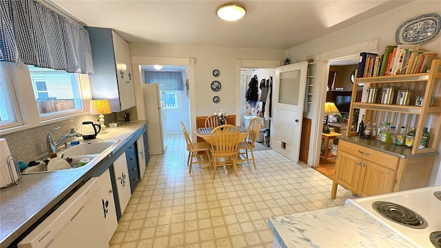 kitchen with tasteful backsplash, sink, white cabinets, and white appliances