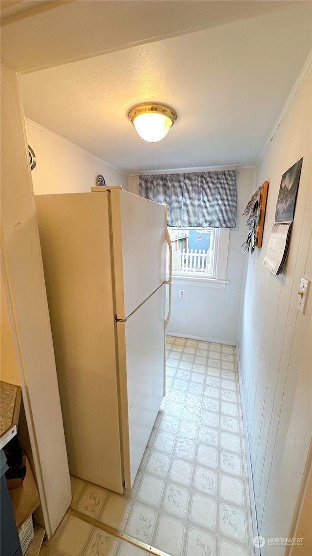 kitchen with white refrigerator and crown molding