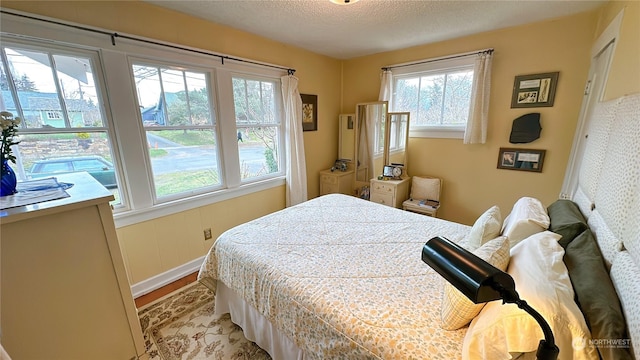 bedroom featuring light hardwood / wood-style floors and a textured ceiling